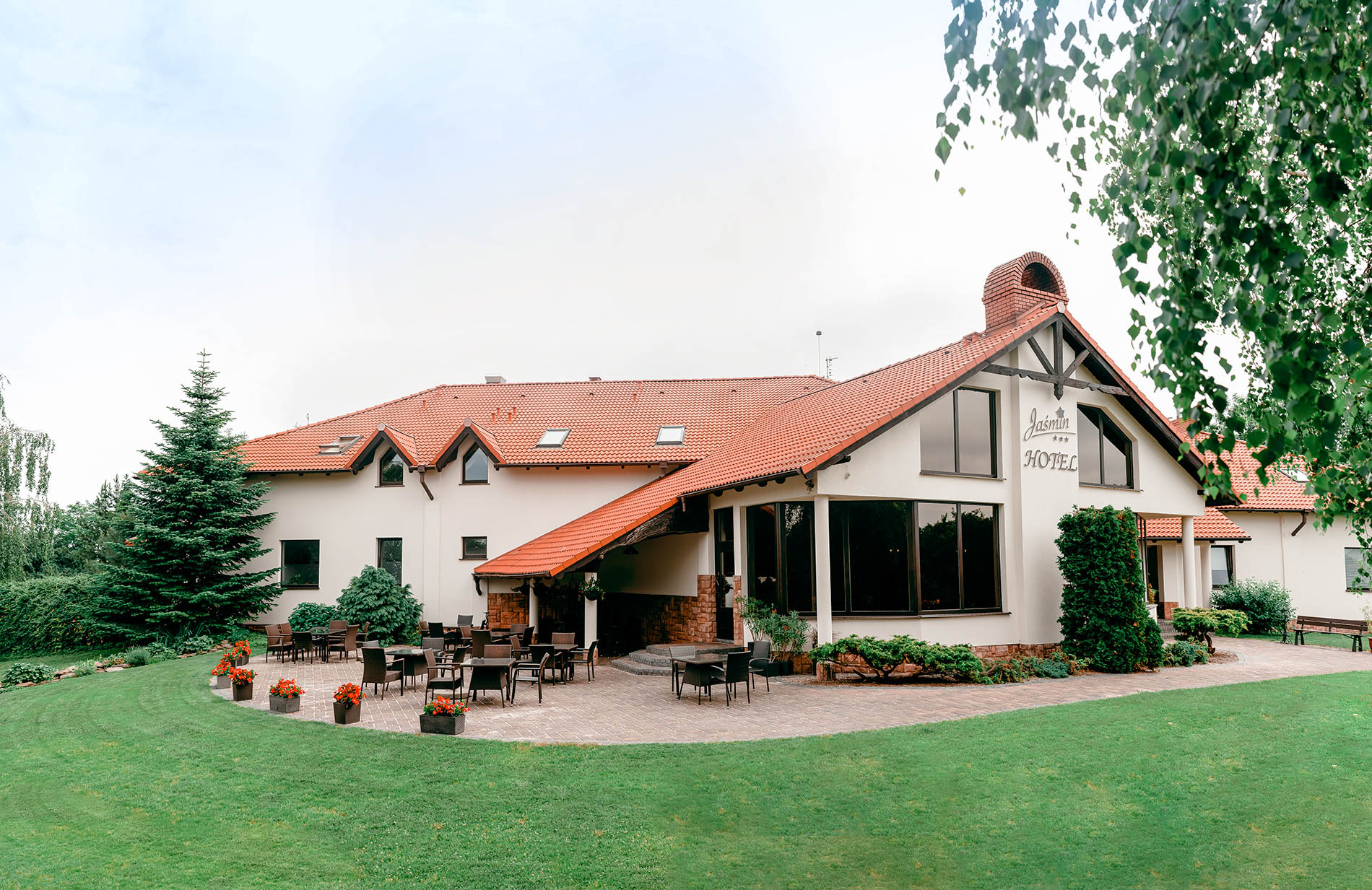Budynek Hotelu Restauracji Jaśmin otoczony zielenią